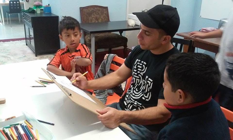 Carlos guiding young students during an art lesson