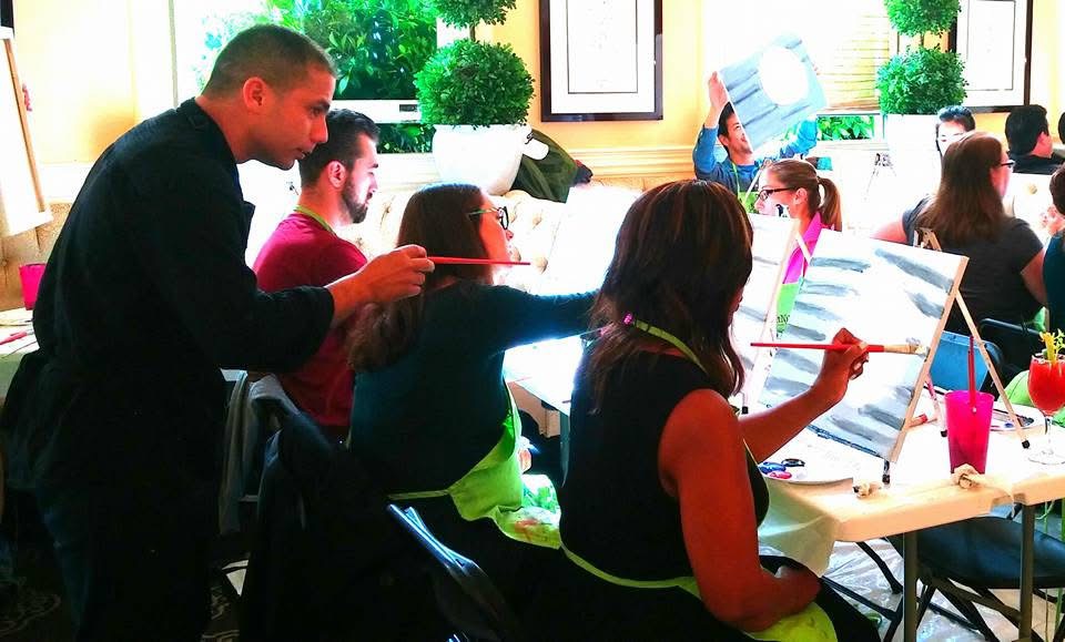 Carlos helping participants during a group painting workshop