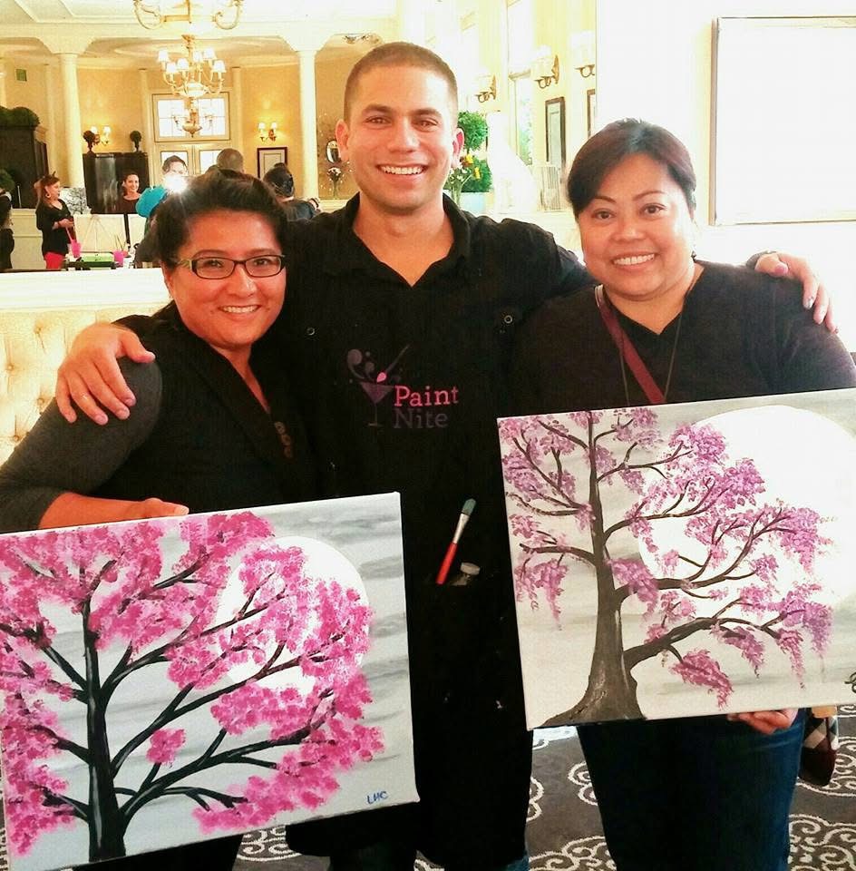 Carlos with two participants holding their cherry blossom paintings
