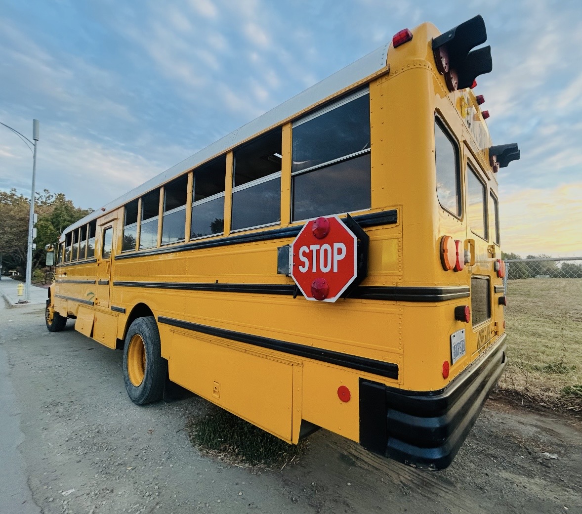 Rear and side view of the yellow school bus before conversion.